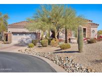 One-story house with desert landscaping, a large garage, and a stone facade at 18672 W Santa Irene Dr, Goodyear, AZ 85338