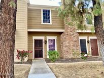 Tan two-story townhome with a red door and walkway at 3329 W Mcrae Way # 4, Phoenix, AZ 85027