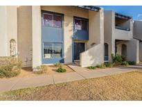 Tan two-story condo building with blue accents and a walkway at 8413 N 55Th Ave, Glendale, AZ 85302