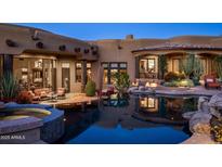 Stunning backyard featuring a pool, spa, and inviting outdoor seating area in a luxurious home at 11237 E Troon Mountain Dr, Scottsdale, AZ 85255