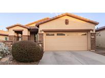 Single-story home with tan exterior, stone accents, and a two-car garage at 16711 S 178Th Dr, Goodyear, AZ 85338
