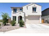 Two-story house with tan exterior, two-car garage, and desert landscaping at 1702 W Flintlock Dr, San Tan Valley, AZ 85144