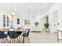 Bright dining area with wood table and black chairs, opens to living room at 23637 N 22Nd St, Phoenix, AZ 85024