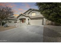 Two-story home with a large driveway and landscaped yard at 44192 W Canyon Creek Dr, Maricopa, AZ 85139