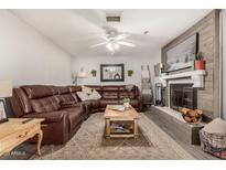 Cozy living room featuring a brown leather sectional sofa and a fireplace at 1018 W Ivanhoe St, Chandler, AZ 85224