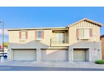 Tan two-story townhome with three-car garage and balcony at 1421 N 80Th Ln, Phoenix, AZ 85043