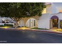 Inviting property entrance with an arched gate, wrought iron door, and lush landscaping at 4825 N 72Nd Way, Scottsdale, AZ 85251