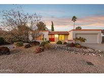 Attractive single-story home with desert landscaping and red front door at 4842 E Surrey Ave, Scottsdale, AZ 85254