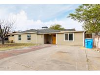 Tan house with orange door, brick driveway, and a tree in the front yard at 1022 E Mariposa St, Phoenix, AZ 85014