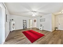 Bright living room with wood-look floors and a red rug at 10826 N 115Th Ave, Youngtown, AZ 85363