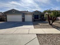 Two-story house with a three-car garage and desert landscaping at 17597 W Aster Dr, Surprise, AZ 85388