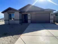 Single-story home with gray exterior, two-car garage, and small front yard at 18411 W Monte Lindo Ln, Surprise, AZ 85387