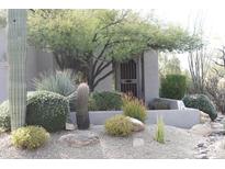 Desert landscaping with cacti, gravel, and a low wall surrounds the home's entrance at 34476 N 68Th Way, Scottsdale, AZ 85266