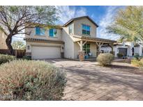 Charming two-story home featuring a covered front porch and brick-paved driveway at 3933 E Alfalfa Dr, Gilbert, AZ 85298