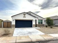 White house with a black garage door and a well-maintained front yard at 42025 W Manderas Ln, Maricopa, AZ 85138