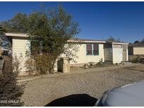 Ranch-style home with a gravel driveway and mature landscaping at 504 W Baseline Rd, Buckeye, AZ 85326