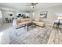 Bright living room with sectional sofa, coffee table, and wood-look floors at 2228 E Campbell Ave # 121, Phoenix, AZ 85016