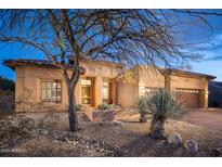 Desert landscaping surrounds this single-story home with a large garage at 29991 N 78Th Pl, Scottsdale, AZ 85266