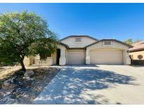 Tan two-story house with a two-car garage and landscaped front yard at 5426 N Rattler Way, Litchfield Park, AZ 85340