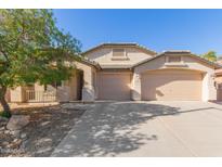 Beige house with two-car garage and landscaping at 5426 N Rattler Way, Litchfield Park, AZ 85340