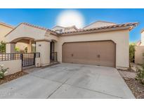 Tan two-story house with a brown door and two-car garage at 3040 N Point Ridge Rd, Buckeye, AZ 85396