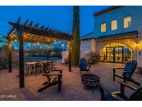 Outdoor patio with pergola, fire pit, and seating area at dusk at 32633 N 137Th St, Scottsdale, AZ 85262