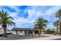 Charming single-story home featuring desert landscaping and a black garage door against a bright blue sky at 4916 E Kathleen Rd, Scottsdale, AZ 85254