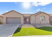 Single-story house with a two-car garage and well-manicured lawn at 4933 W Melody Ln, Laveen, AZ 85339