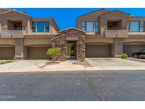 Front view of a two-story townhome with attached garage and stone accents at 7445 E Eagle Crest Dr # 1065, Mesa, AZ 85207