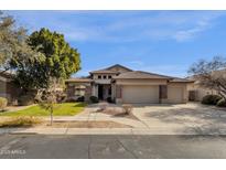 Single-story home with three-car garage and manicured lawn at 7893 S Stephanie Ln, Tempe, AZ 85284