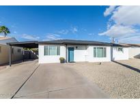 Remodeled mid-century home with carport, and a teal front door at 908 E Cavalier Dr, Phoenix, AZ 85014