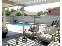 Inviting backyard with sparkling pool, patio furniture, and pergola at 9207 W Highland Ave, Phoenix, AZ 85037