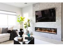 Living room with linear fireplace, built-in media niche and large windows at 10018 E Hillside Dr, Scottsdale, AZ 85255