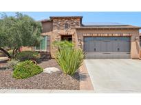 Single-story home with brick facade, solar panels, and landscaped front yard at 12736 W Auburn Dr, Peoria, AZ 85383