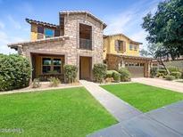 Charming two-story stone home with a well-manicured lawn and inviting curb appeal at 4813 S Quantum Way, Mesa, AZ 85212