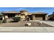 Single-story home with a two-car garage and desert landscaping at 4905 W Magellan Dr, New River, AZ 85087