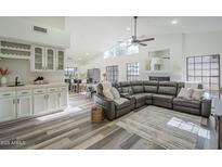 Spacious living room featuring a large sectional sofa and a wood-burning fireplace at 605 S 30Th Cir, Mesa, AZ 85204