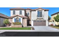 Two-story home with stone accents and a three-car garage at 910 E Canyon Way, Chandler, AZ 85249