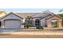 Single-story home with a two-car garage and well-maintained landscaping at 14309 W Rico Dr, Sun City West, AZ 85375