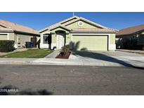 Light green one-story house with a two-car garage and well-maintained landscaping at 1434 E Detroit St, Chandler, AZ 85225