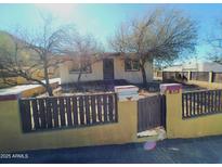 Ranch-style home with fenced yard and mature trees at 211 W Kiser St, Superior, AZ 85173