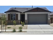 Charming single-story home featuring a neutral color palette, stone accents, and a well-manicured front yard at 22311 W Monona Ln, Surprise, AZ 85387