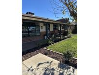 Charming ranch home with brick facade, covered porch, and well-manicured lawn at 2649 N Granite Reef Rd, Scottsdale, AZ 85257