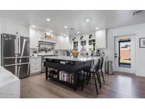 Updated kitchen with white cabinets and a large island at 2649 N Granite Reef Rd, Scottsdale, AZ 85257
