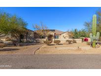 Desert landscaping surrounds this single-story home with a large driveway and 3-car garage at 3630 W Bohl St, Laveen, AZ 85339