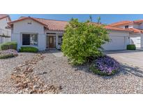 Single-story home with a two-car garage, desert landscaping, and a welcoming front entrance at 5335 W Bloomfield Rd, Glendale, AZ 85304