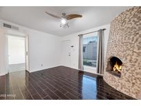 Living room with fireplace, dark hardwood floors, and ceiling fan at 8014 E Oak St, Scottsdale, AZ 85257