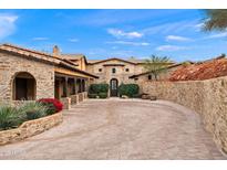 Stately stone home featuring a beautiful brick driveway, mature landscaping, and a classic tiled roof at 16117 E Shooting Star Trl, Fountain Hills, AZ 85268