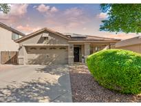 House exterior featuring a three-car garage and well-manicured landscaping at 677 S 153Rd Ln, Goodyear, AZ 85338