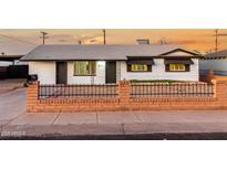 Charming single-story home with a well-manicured lawn and brick fence at 132 W Beautiful Ln, Phoenix, AZ 85041